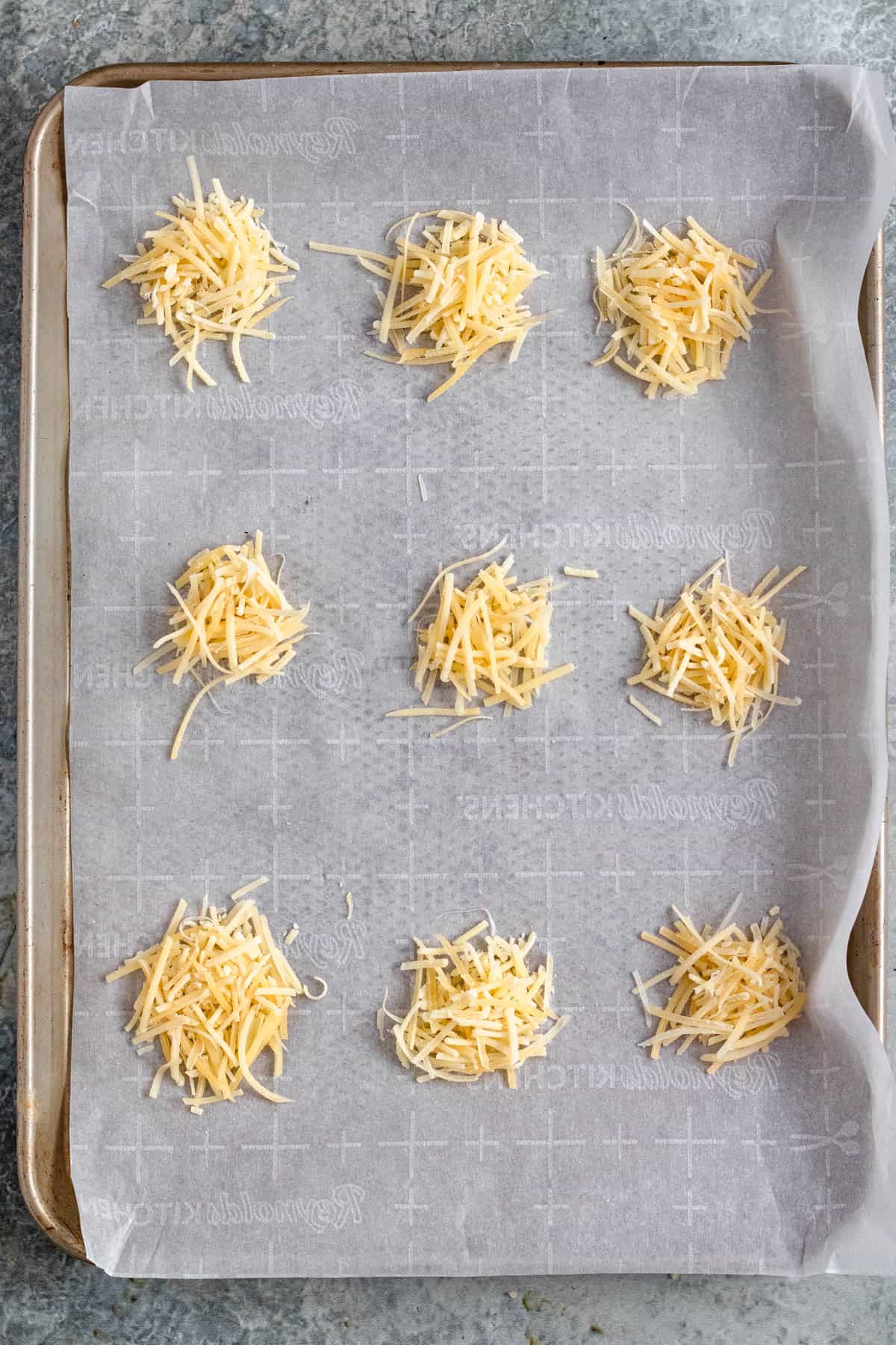 1 tablespoon piles of parmesan cheese on a baking sheet