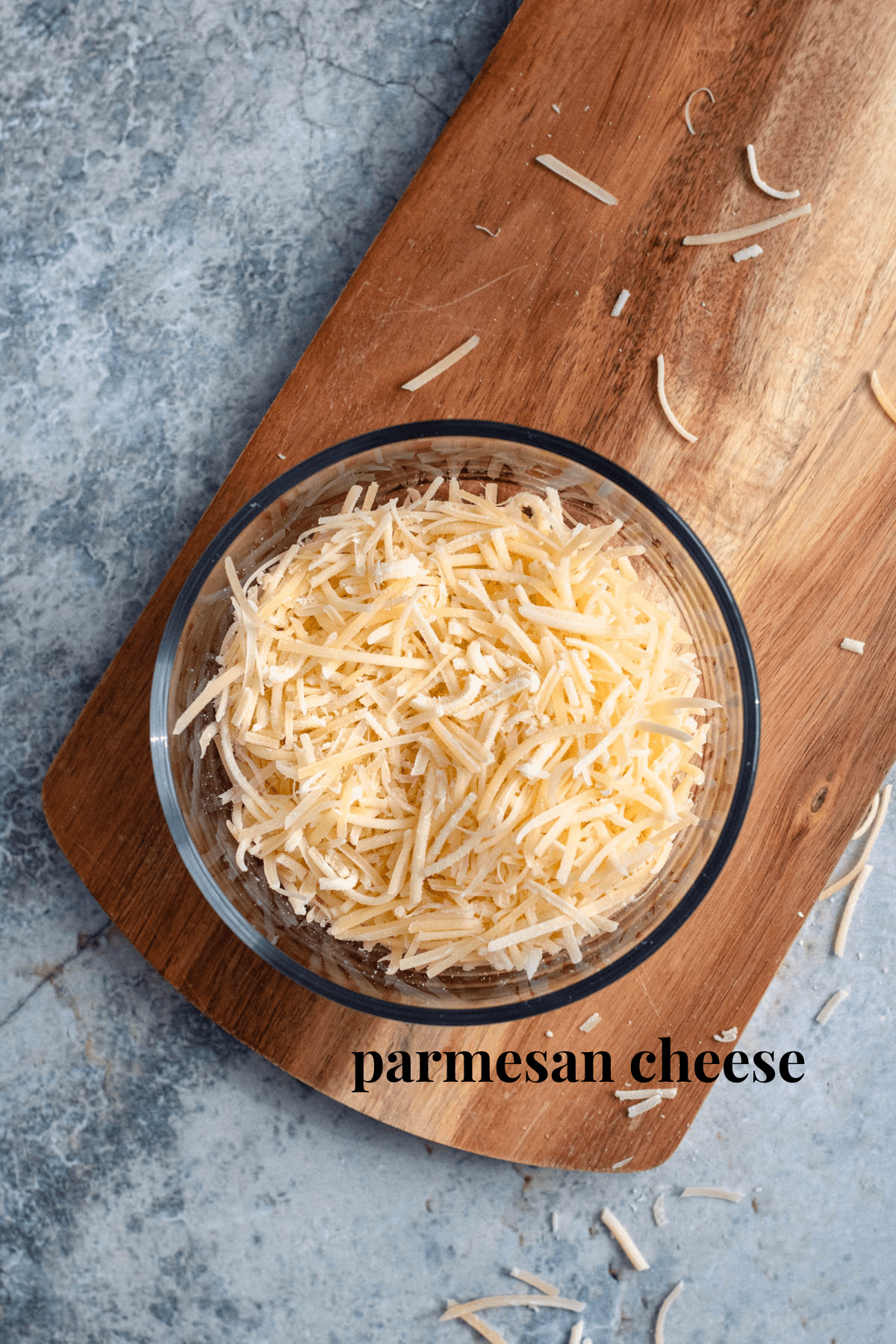 parmesan cheese in a glass bowl with a light colored background