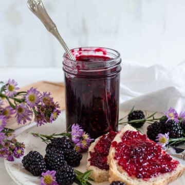 blackberry jam in a small jar with a light colored background