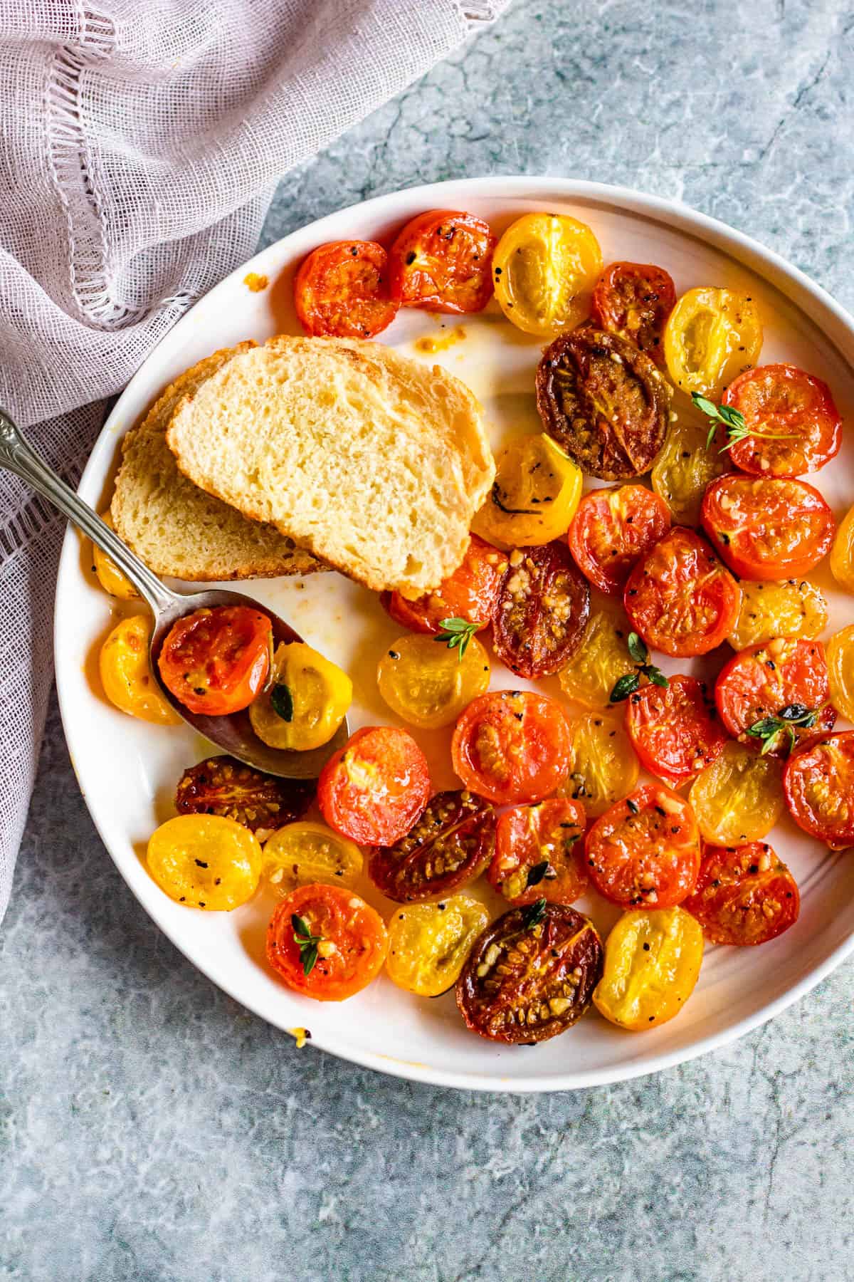 roasted cherry tomatoes on a round plate with a light colored background
